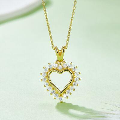 a necklace with a heart shaped pendant on a green surface