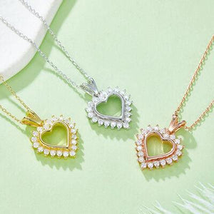 three necklaces on a green surface with a white feather