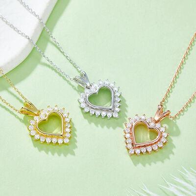 three necklaces on a green surface with a white feather
