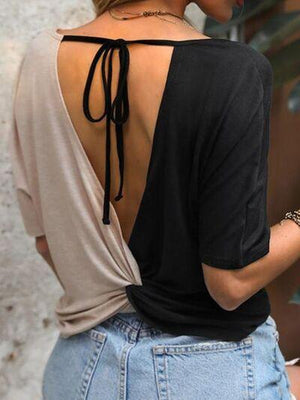 a woman wearing a black top with a back tie