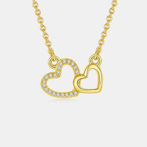 a gold necklace with two hearts on it