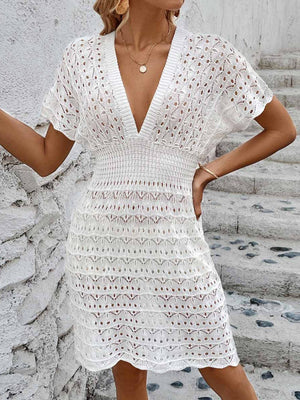 a woman wearing a white crochet dress