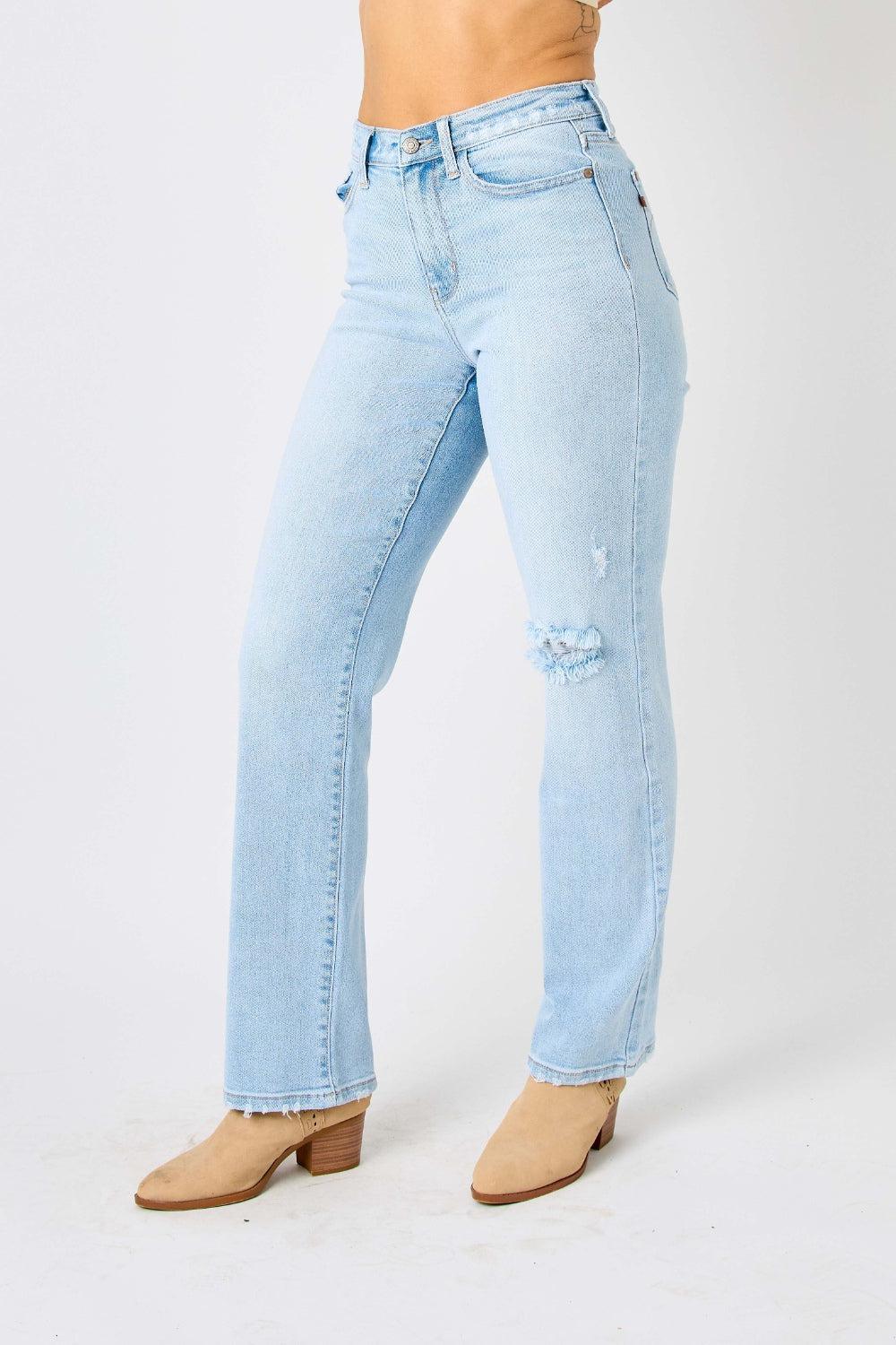 a woman in a white tank top and blue jeans