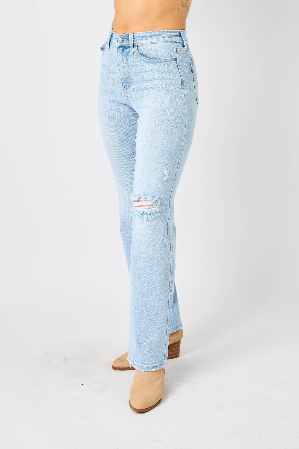a woman in a white tank top and blue jeans