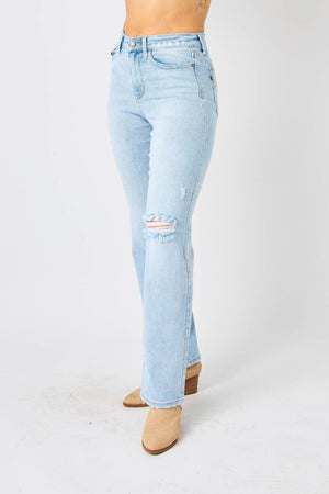 a woman in a white tank top and blue jeans
