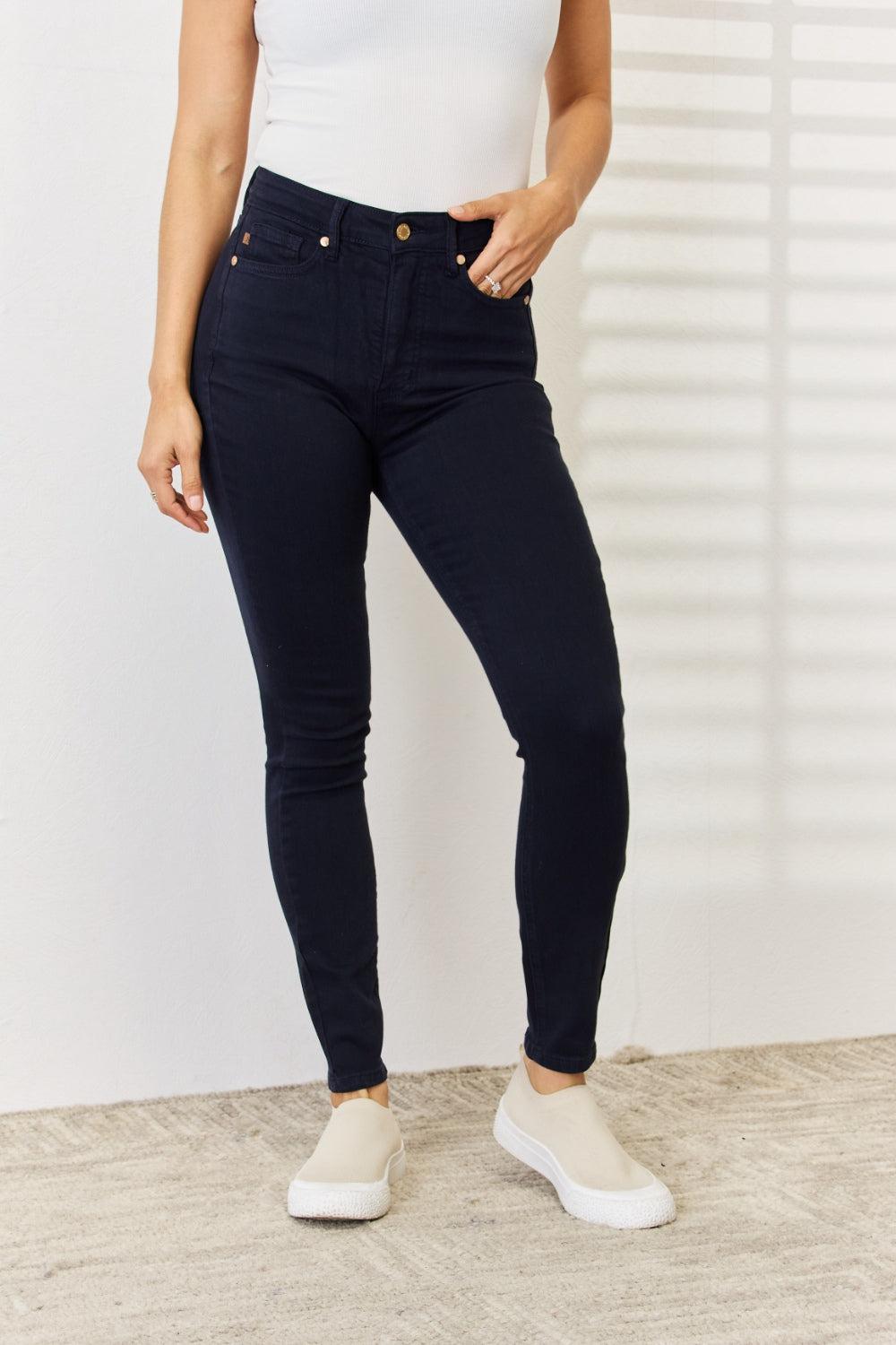 a woman in a white tank top and jeans