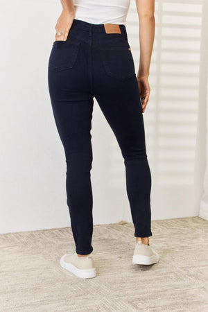 a woman in a white tank top and jeans