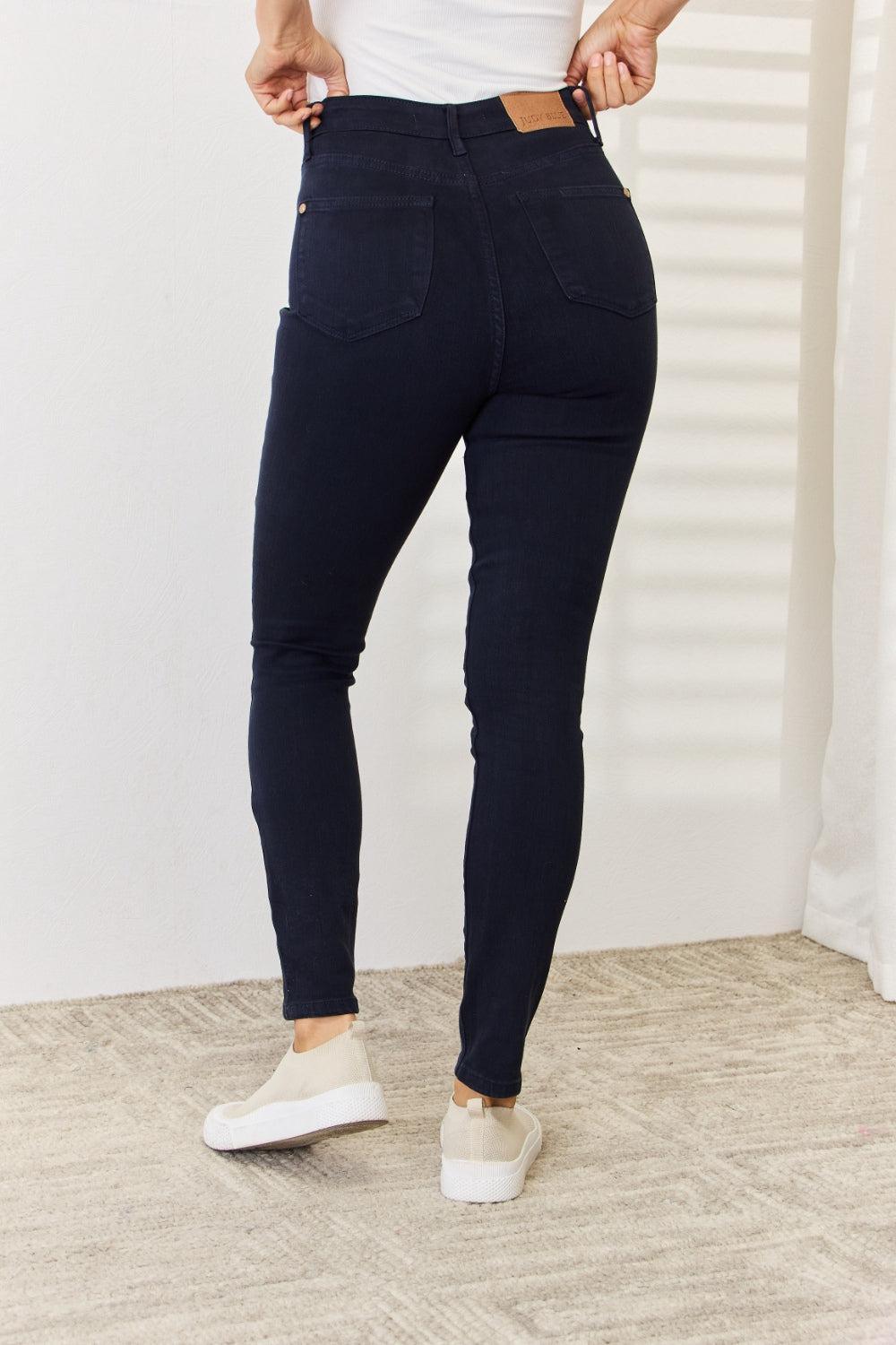 a woman in a white tank top and jeans