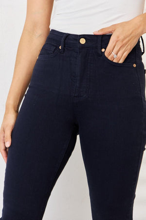 a woman in a white tank top and black pants