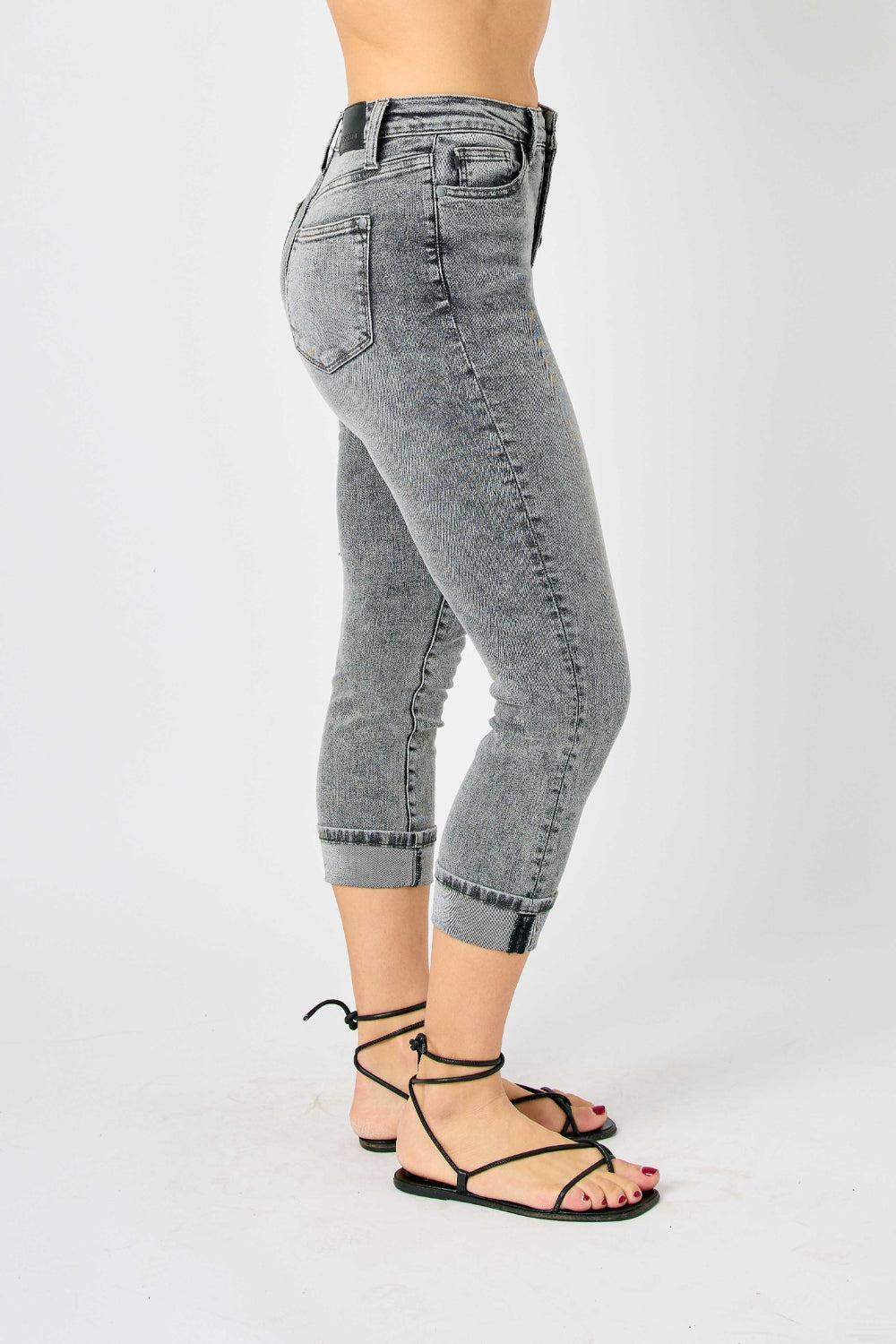 a woman in high rise jeans is posing for a picture