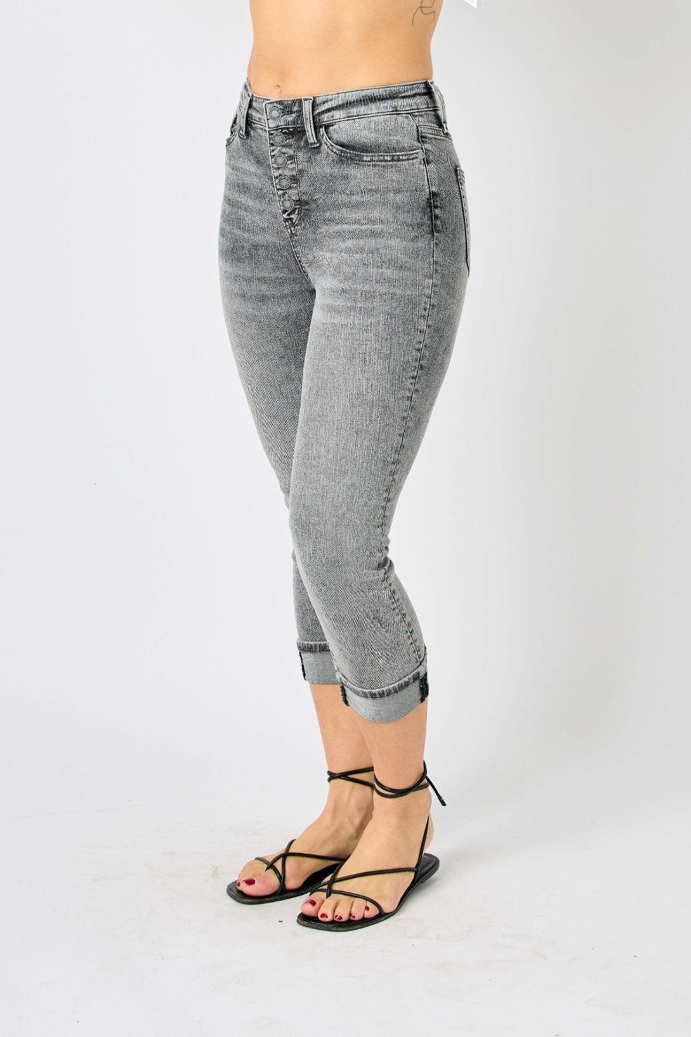 a woman in a white top and grey jeans