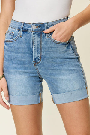 a woman wearing a white top and blue shorts