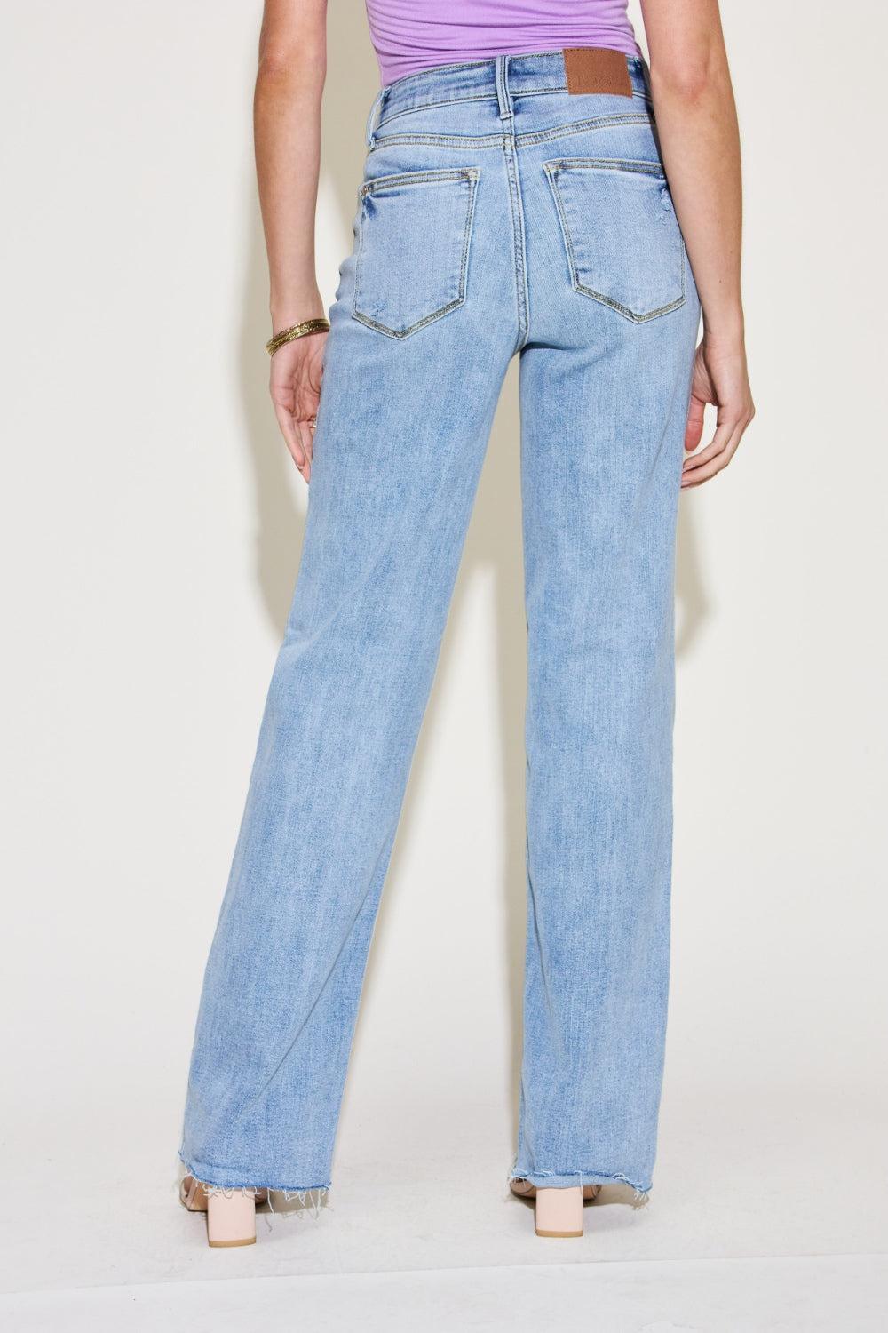 a woman wearing high rise jeans and a tank top