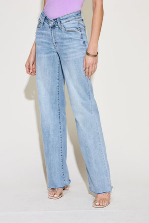 a woman in a purple tank top and blue jeans
