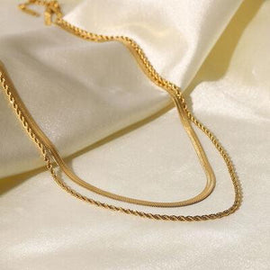 a close up of a gold necklace on a white cloth