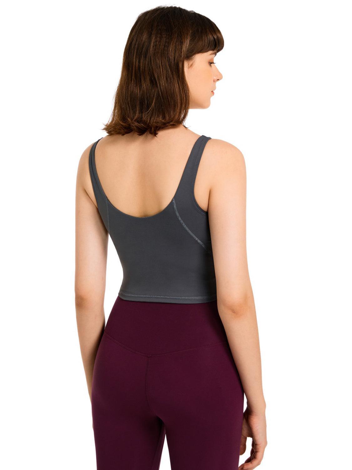 the back of a woman wearing a grey top and purple leggings
