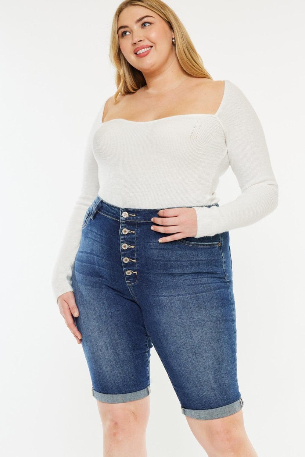 a woman in a white top and denim shorts