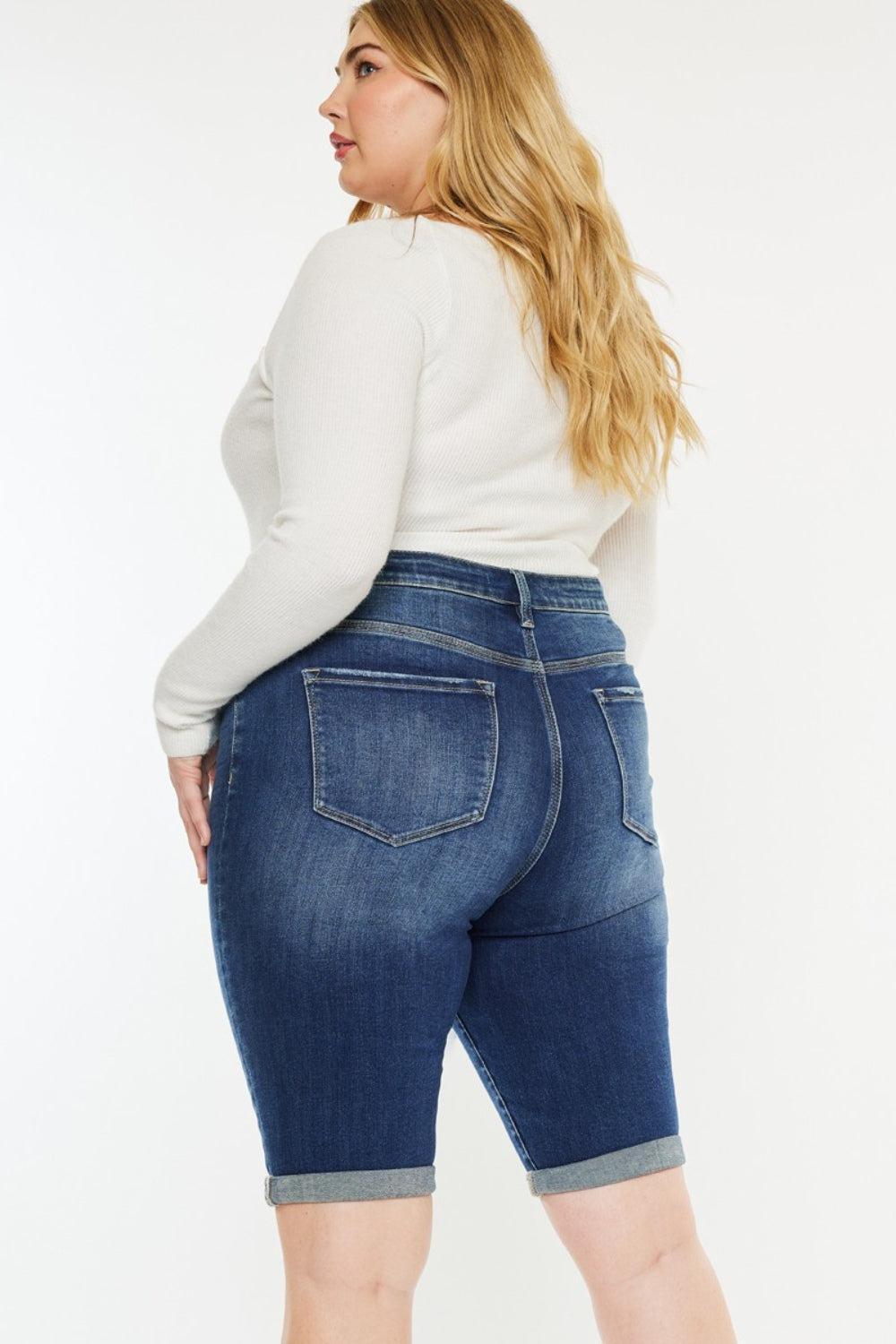 a woman in a white top and jeans shorts