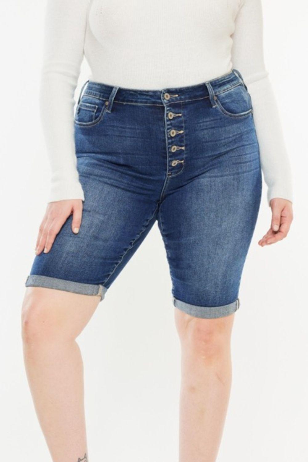 a woman in a white top and jeans shorts