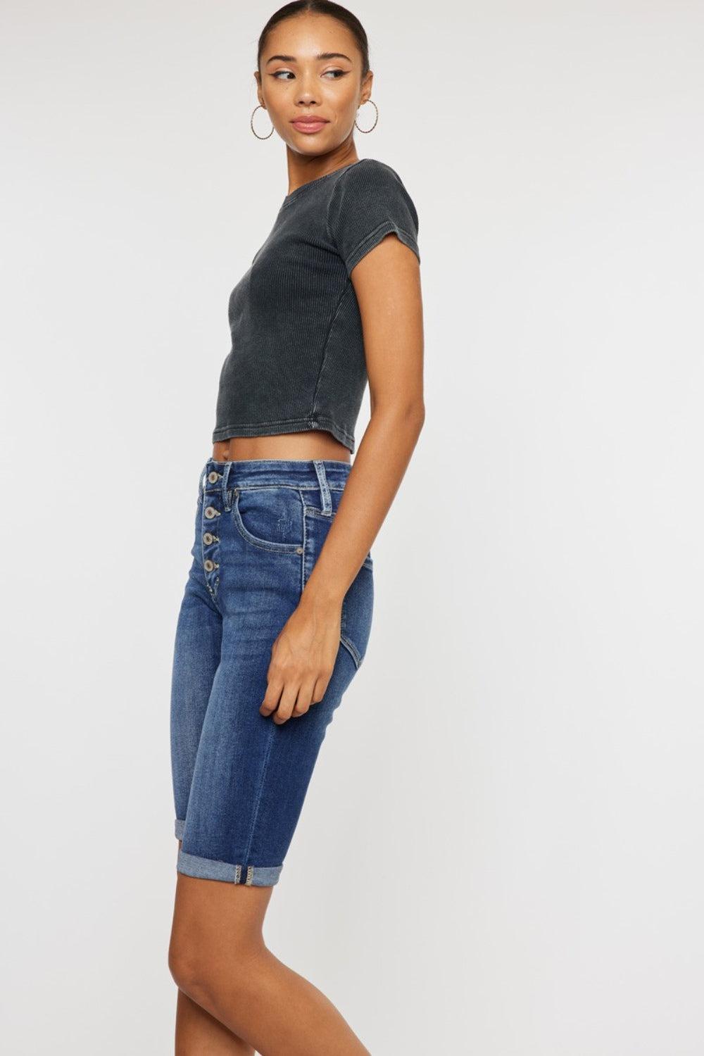 a woman in a cropped top and denim shorts