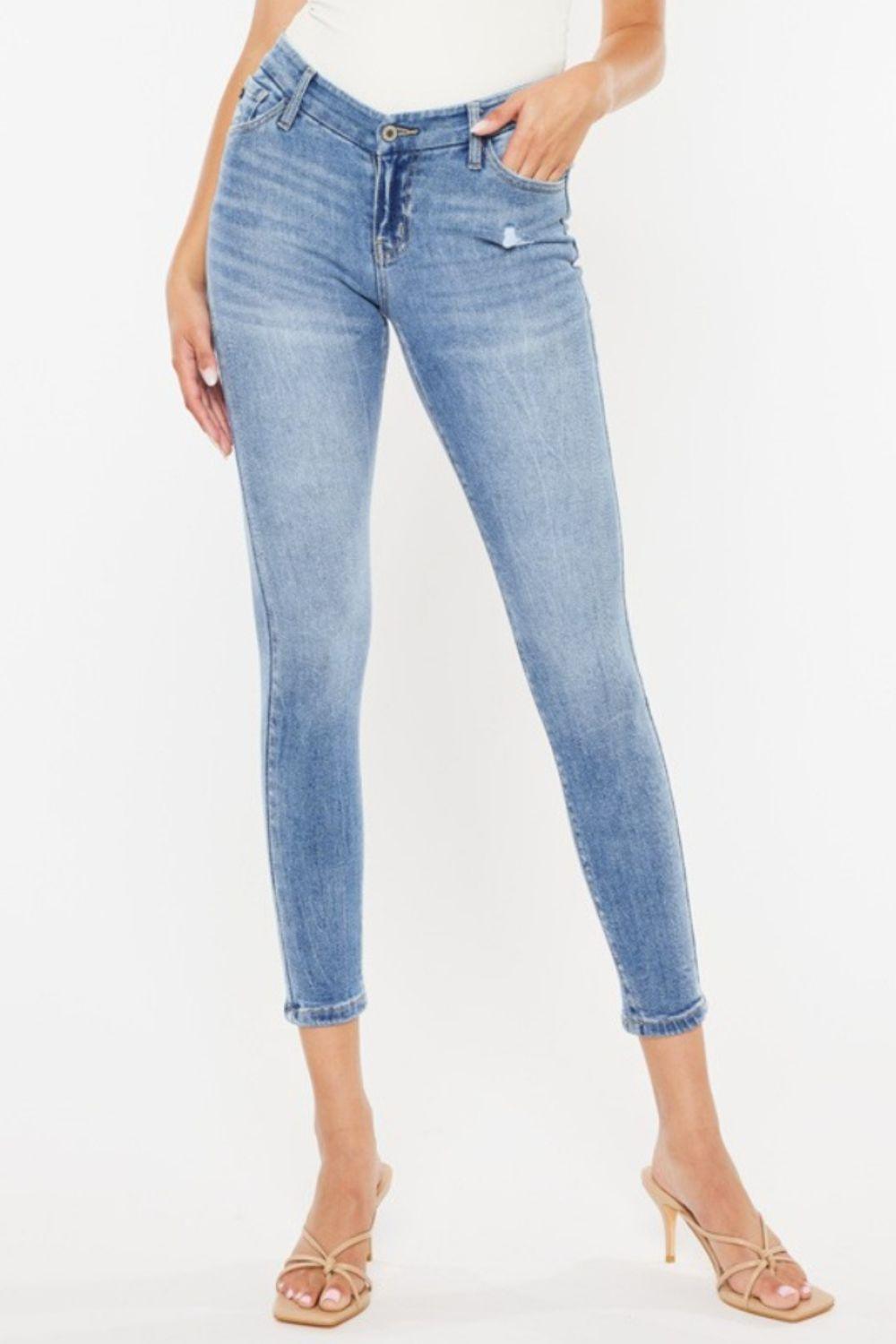 a woman in a white tank top and jeans