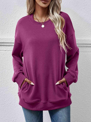 a woman wearing a purple sweatshirt and jeans