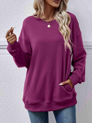 a woman wearing a purple sweatshirt and jeans
