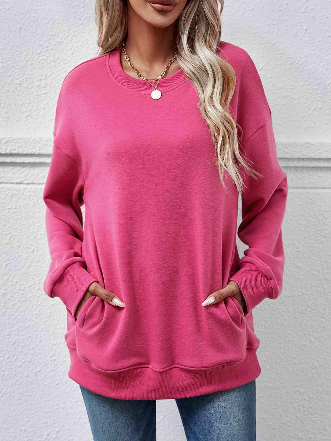 a woman wearing a pink sweatshirt and jeans