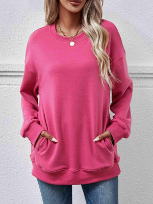 a woman wearing a pink sweatshirt and jeans