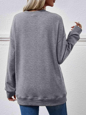 a woman wearing a grey sweatshirt and jeans