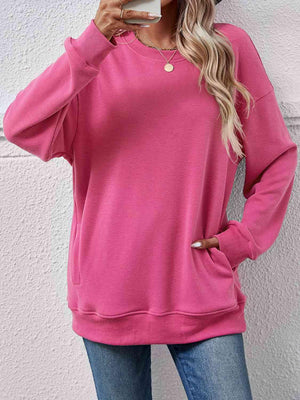 a woman wearing a pink sweatshirt and jeans