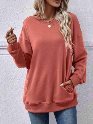 a woman wearing a pink sweatshirt and jeans
