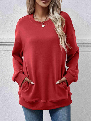 a woman wearing a red sweatshirt and jeans