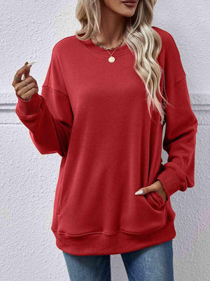 a woman wearing a red sweatshirt and jeans