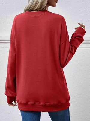 a woman wearing a red sweatshirt and jeans