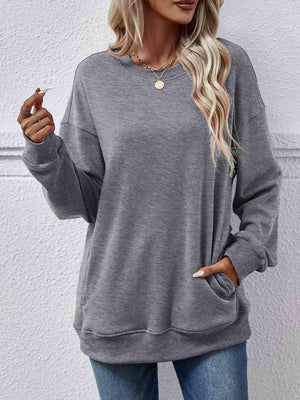 a woman wearing a grey sweatshirt and jeans