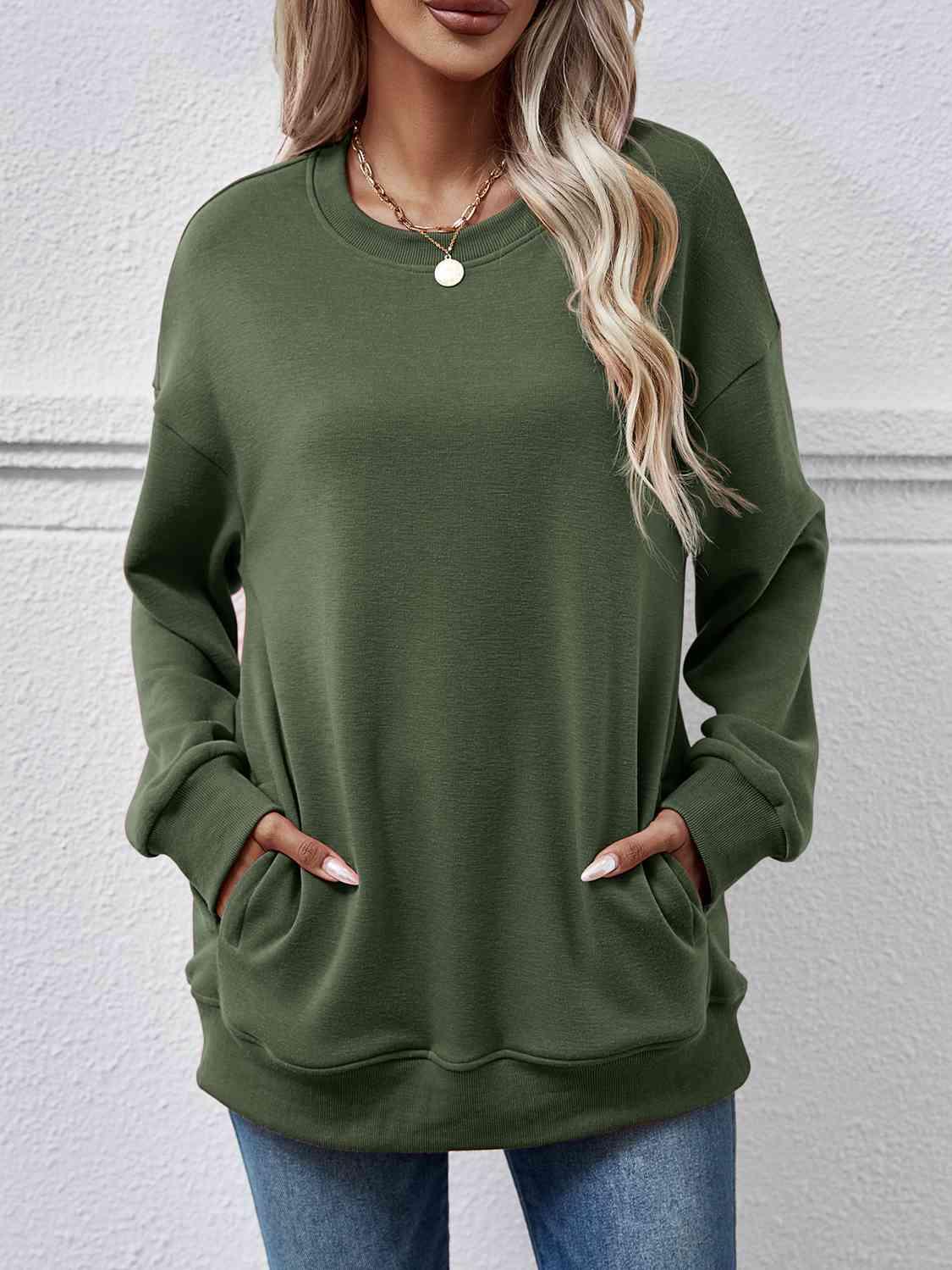 a woman wearing a green sweatshirt and jeans