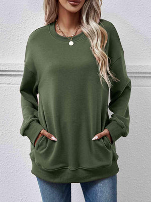 a woman wearing a green sweatshirt and jeans