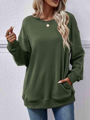 a woman wearing a green sweatshirt and jeans