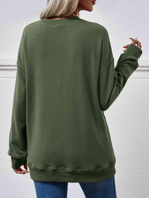 a woman wearing a green sweatshirt and jeans