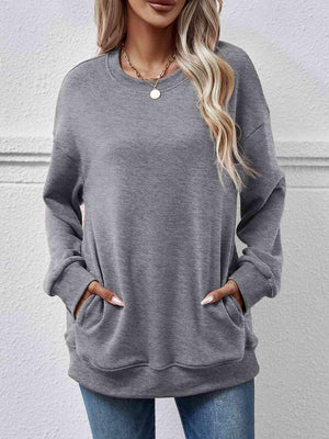 a woman wearing a grey sweatshirt and jeans