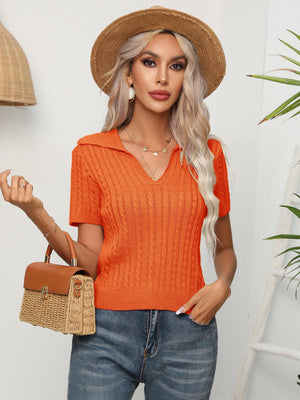 a woman wearing an orange sweater and a straw hat