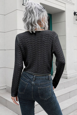 a woman with grey hair wearing a black sweater and jeans