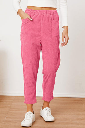 a woman in a white top and pink pants