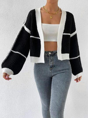 a woman wearing a black and white sweater and jeans