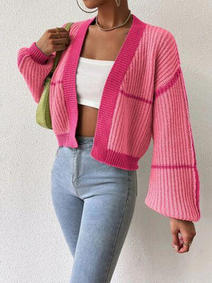 a woman wearing a pink cardigan sweater and jeans