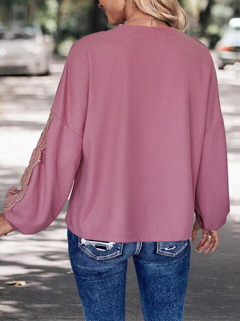a woman wearing a pink top and jeans