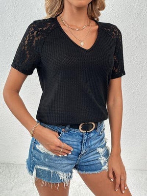 a woman wearing a black top and denim shorts