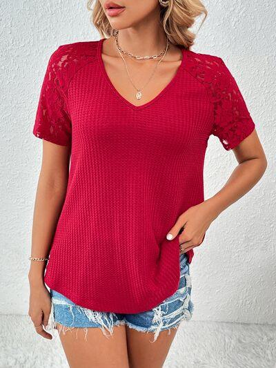 a woman wearing a red top and denim shorts