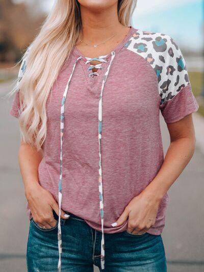 a woman with blonde hair wearing a pink shirt and jeans